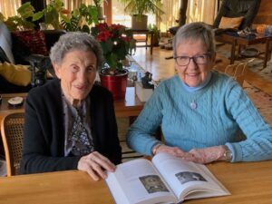 A photo of Marilyn Lavin and Nancy Hodges seated at a table with a book.